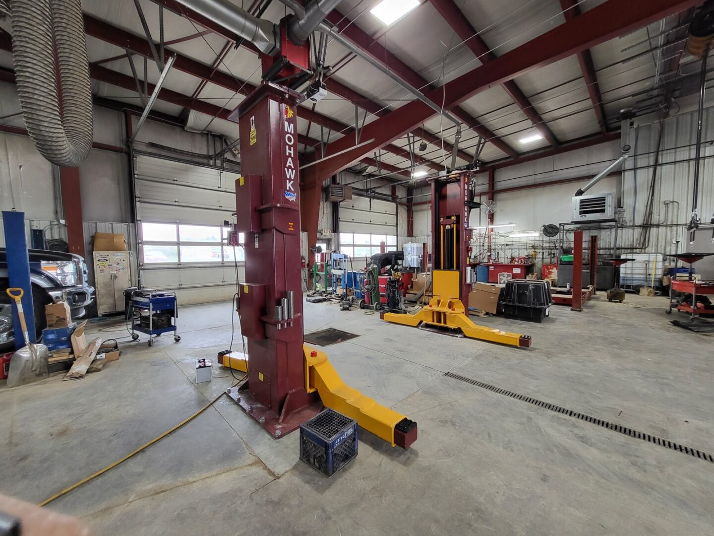 Automotive repair shop with Mohawk 2-post lifts and yellow mobile column lift units on concrete floor