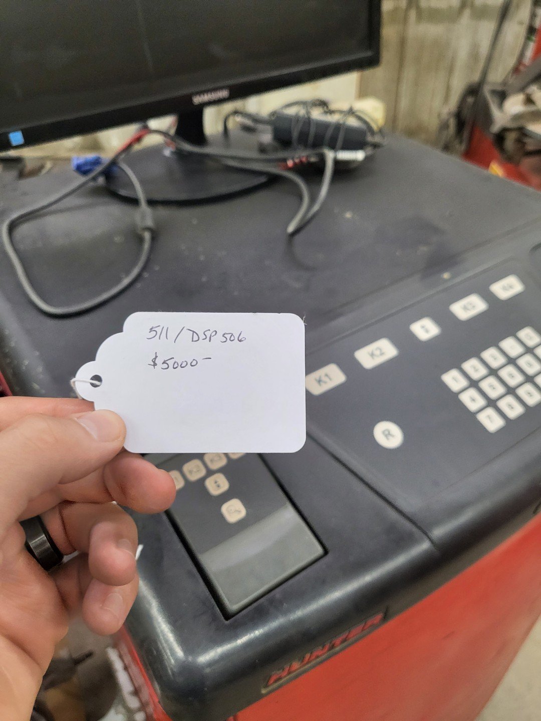Hunter DSP506 wheel balancer machine with price tag showing $5000 for sale in auto shop