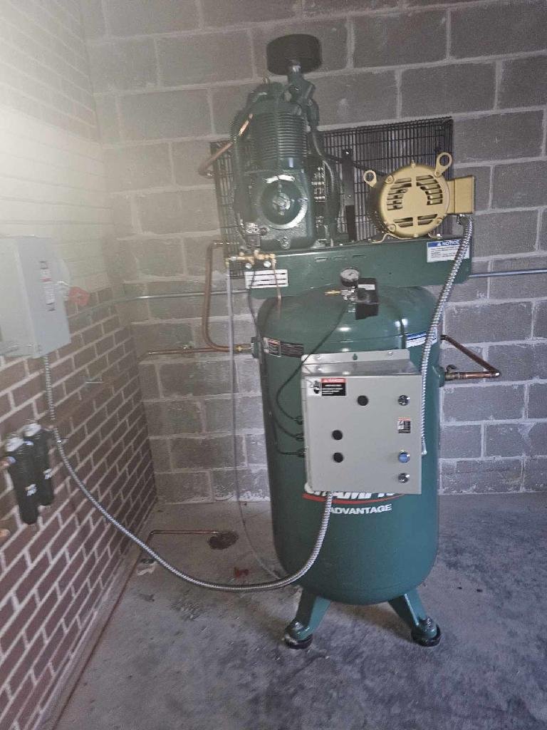 Champion Advantage vertical air compressor installed in auto shop utility room with cinder block walls