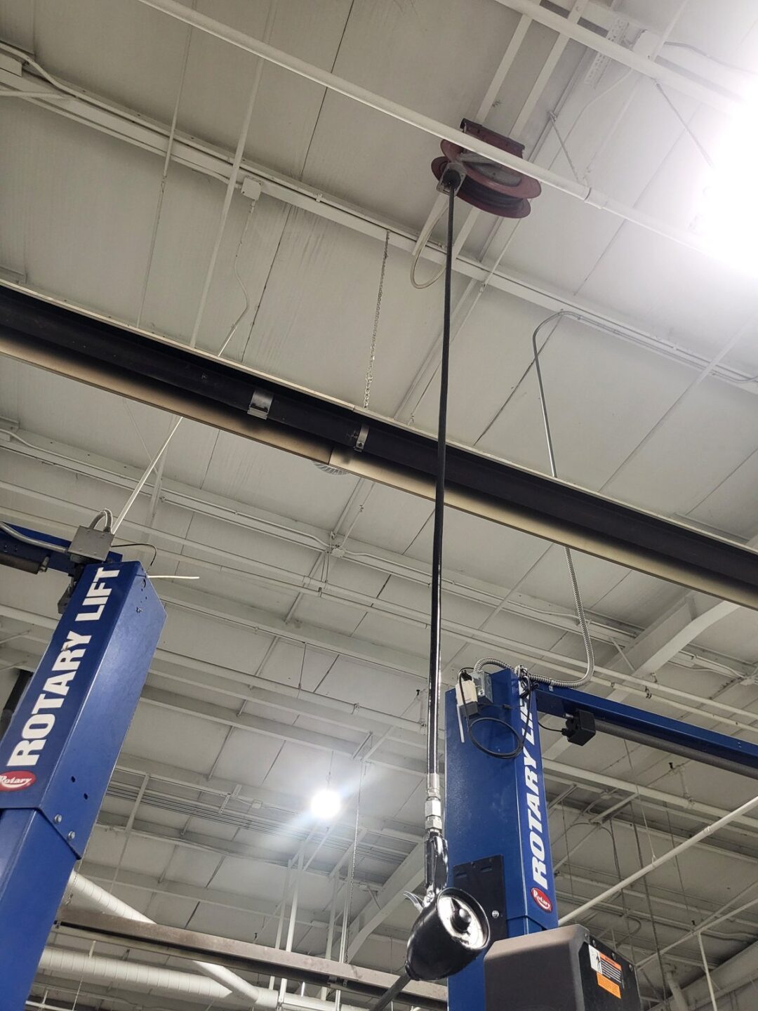 Rotary Lift 2-post automotive lifts installed in commercial auto shop with overhead reel and lighting