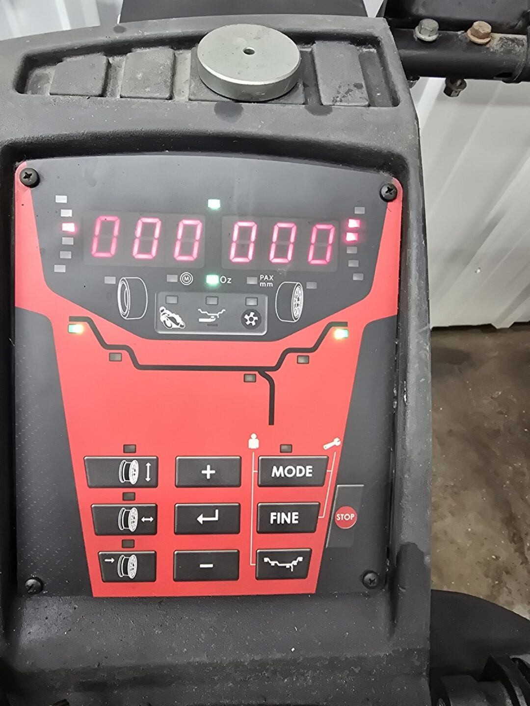 Wheel balancer control panel with digital display showing 000 000 and mode/fine adjustment buttons