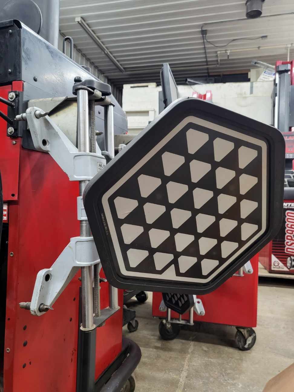 Hunter wheel alignment target head closeup inside automotive service shop