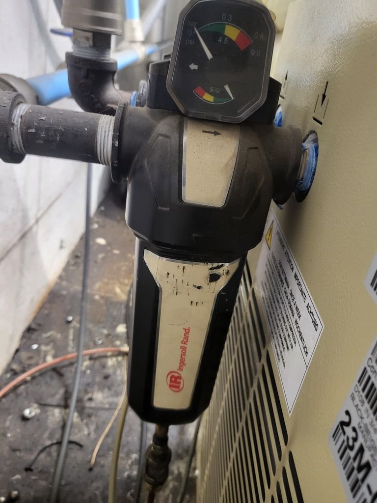 Ingersoll Rand air filter regulator mounted on compressor unit in automotive shop